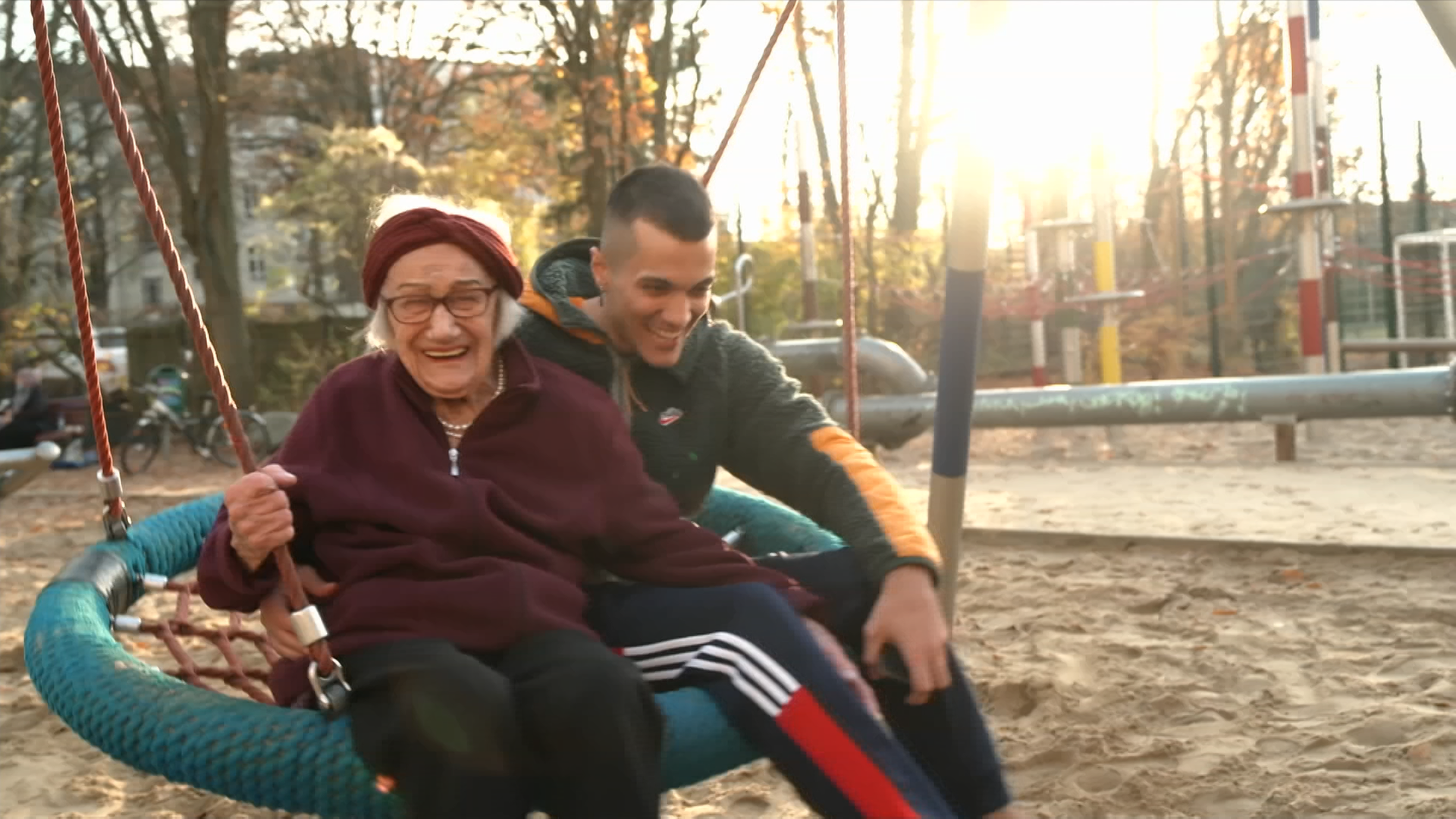 Amir und Agnes auf lachend auf einer Schaukel