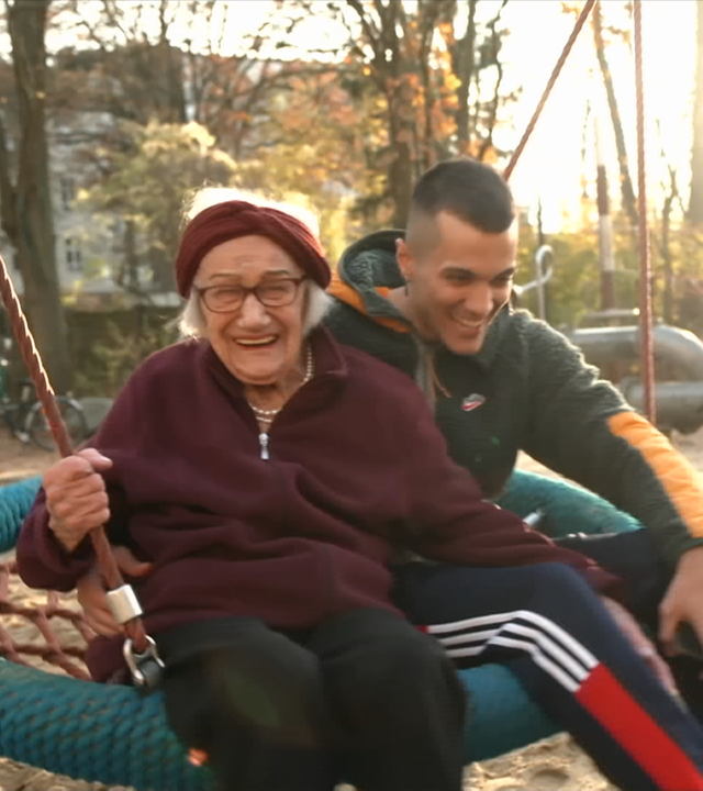 Amir und Agnes auf lachend auf einer Schaukel