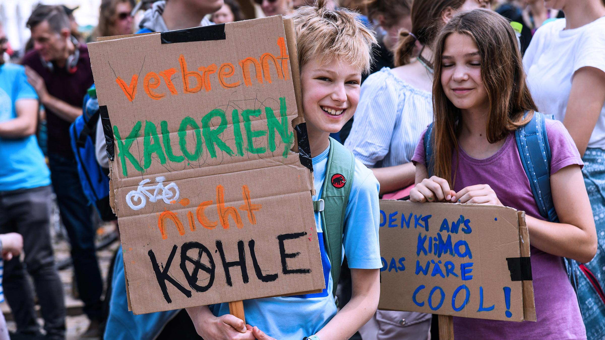 Schülerinnen und Schüler demonstrieren mit Protestplakaten bei Fridays for Future.
