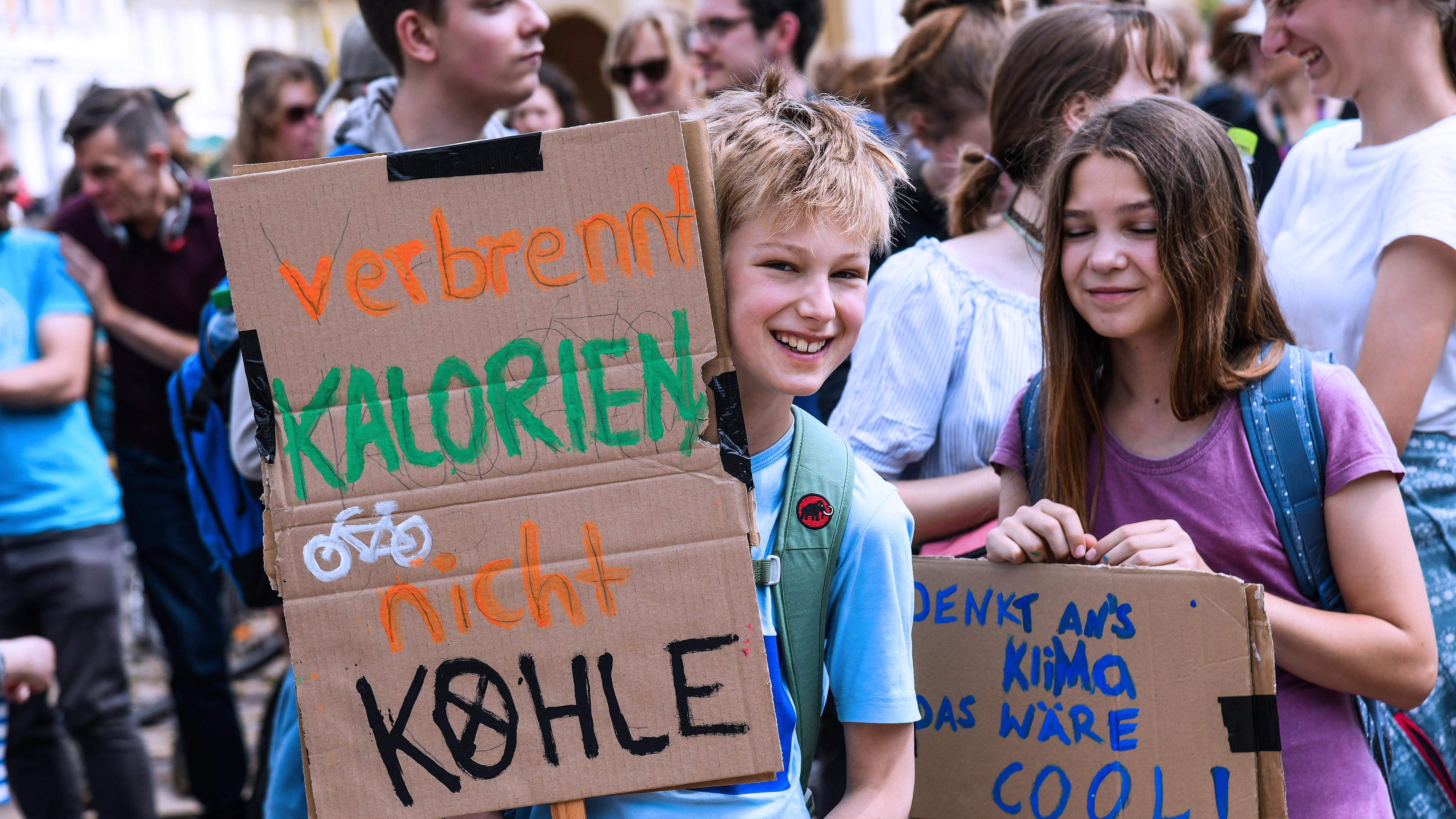 Schülerinnen und Schüler demonstrieren mit Protestplakaten bei Fridays for Future.