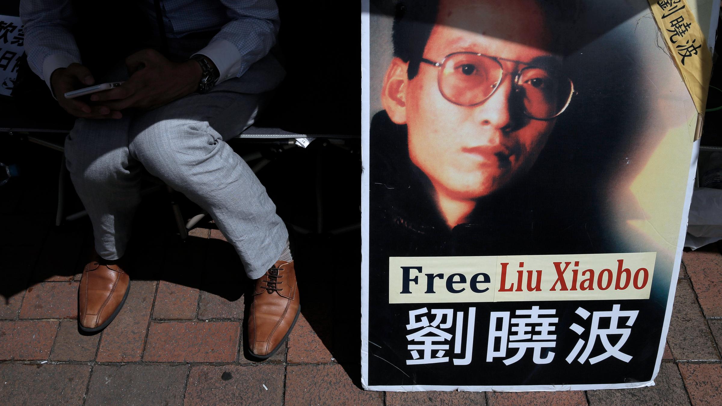 Ein Demonstrant zeigt während einer Demonstration vor dem chinesischen Verbindungsbüro in Hongkong ein Porträt des inhaftierten chinesischen Friedensnobelpreisträgers Liu Xiaobo