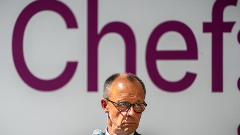 Friedrich Merz.Im Hintergund steht in pinker Farbe: Chef