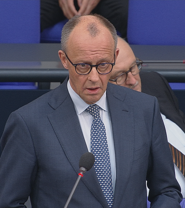 Friedrich Merz spricht im Bundestag. Er trägt einen blau-grauen Anzug.