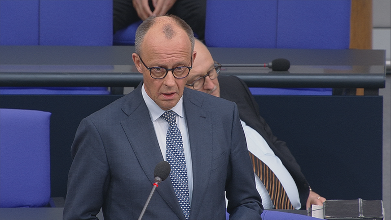 Friedrich Merz spricht im Bundestag. Er trägt einen blau-grauen Anzug.