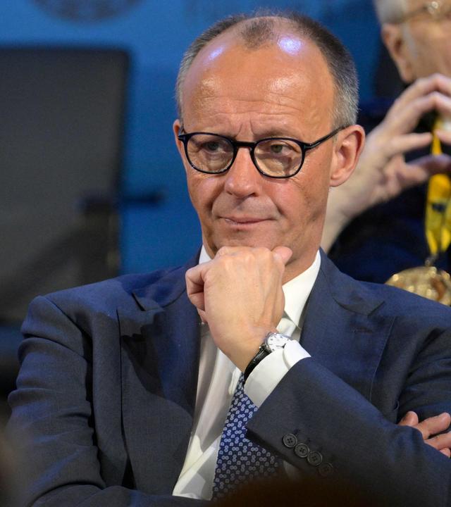 Bundeskanzler Merz hört einer Rede zu. 