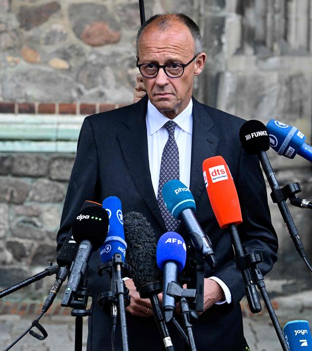 Friedrich Merz gibt eine Pressestaement zum Attentäter auf den CSD in Berlin. Im Hintergrund ist dei Mauer einer Kirche zu sehen.