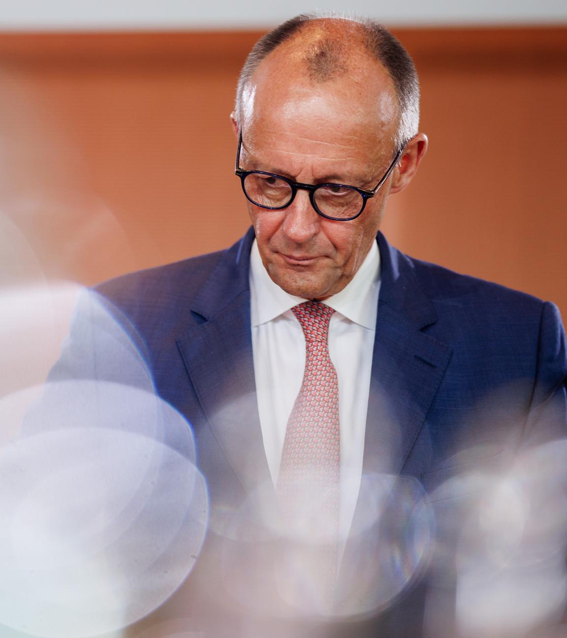 Friedrich Merz vor Holzwand bei einer Kabinettssitzung.