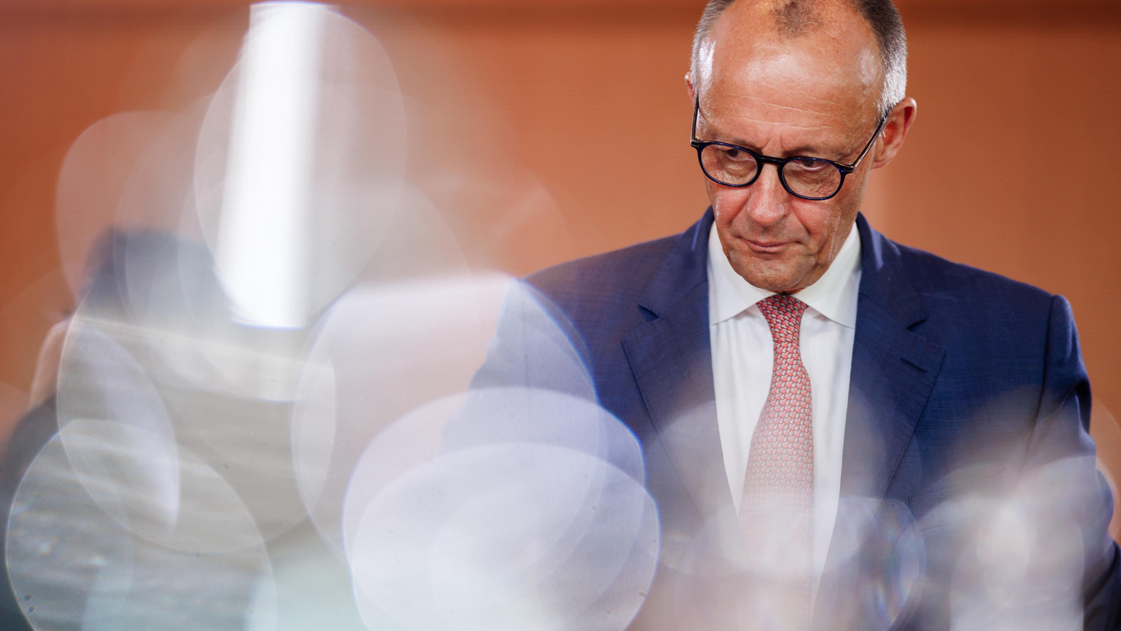 Friedrich Merz vor Holzwand bei einer Kabinettssitzung.