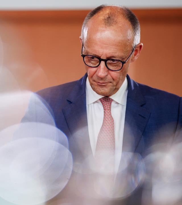Friedrich Merz vor Holzwand bei einer Kabinettssitzung.
