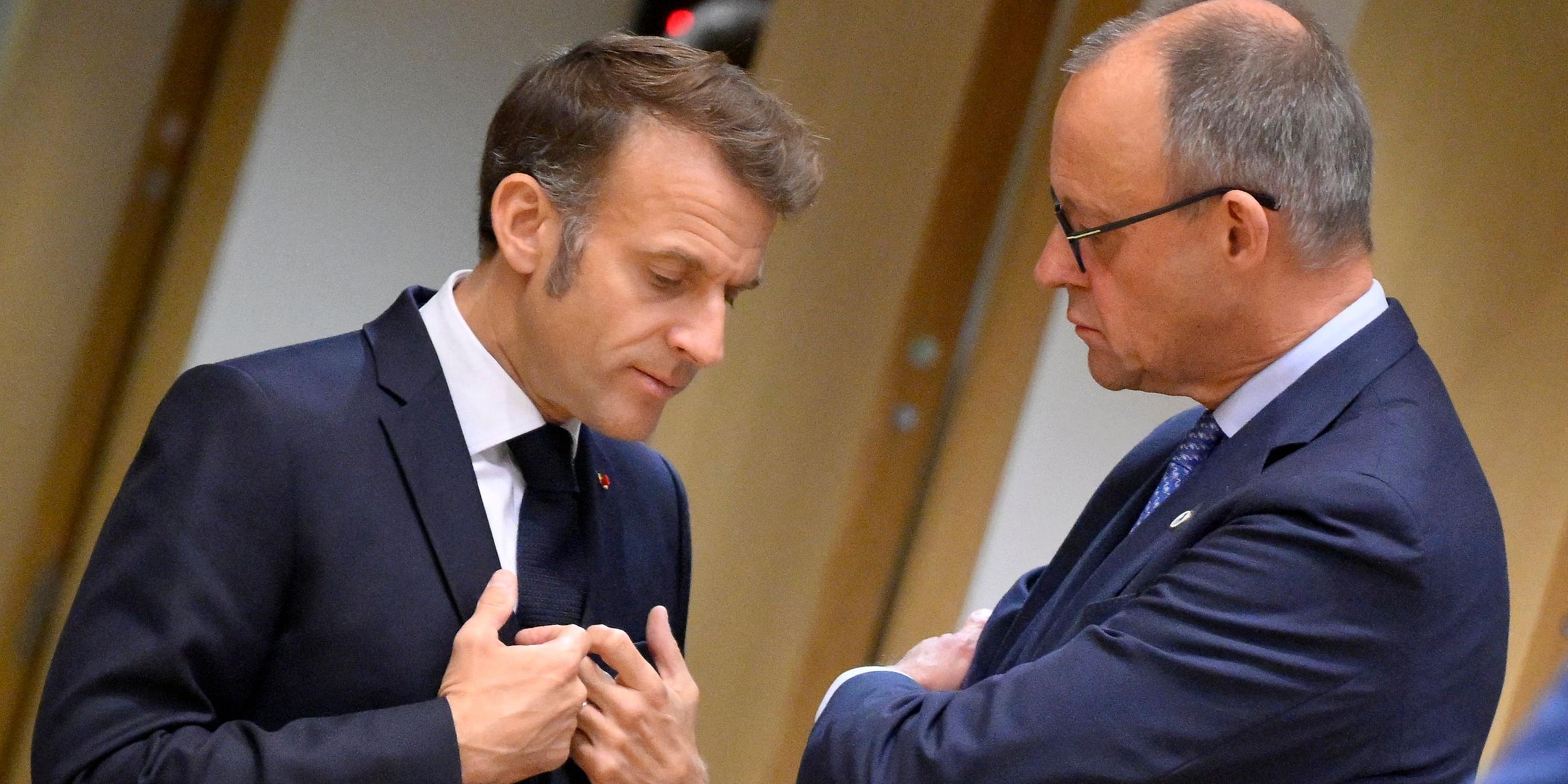 Bundeskanzler Friedrich Merz (r) spricht mit Frankreichs Präsident Emmanuel Macron bei ihrer Ankunft zu einem Treffen des Europäischen Rates in Brüssel