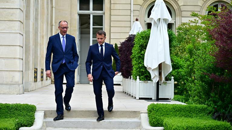 Merz und Macron laufen eine Treppe herunter