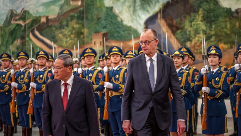 Bundeskanzler Friedrich Merz (CDU) wird von Li Qiang, Ministerpräsident von China, mit militärischen Ehren in der Großen Halle des Volkes begrüss