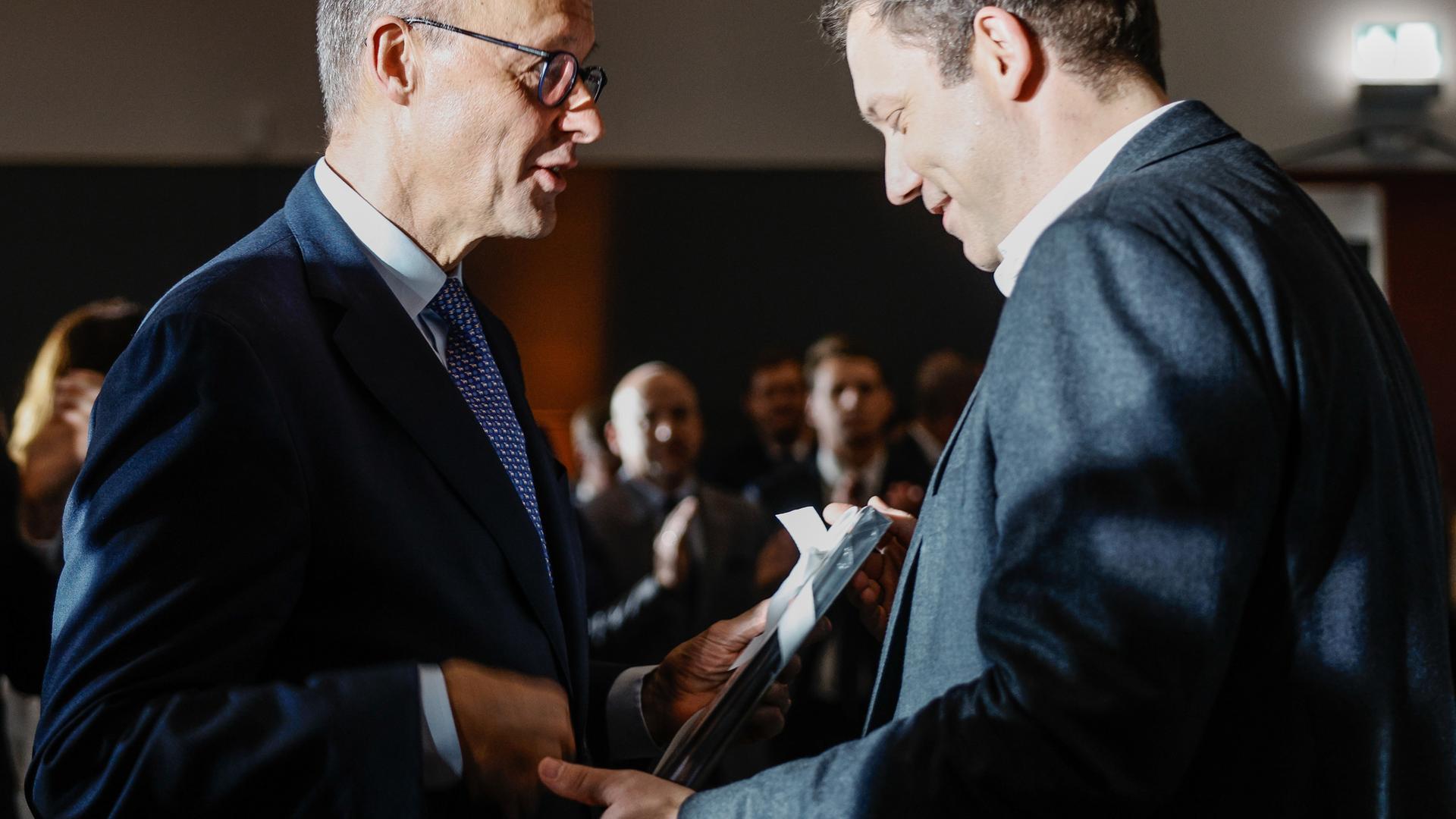 Berlin: Bundeskanzler Friedrich Merz (l, CDU) und Lars Klingbeil (SPD), Bundesminister der Finanzen, unterhalen sich beim Geburtstagsempfang anlässlich des 70. Geburtstags von Merz.