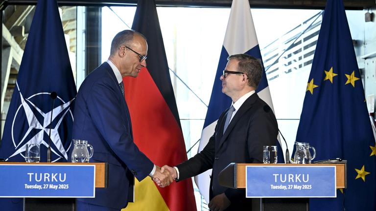 Bundeskanzler Friedrich Merz (links) und der finnische Ministerpräsident Petteri Orpo geben sich am Ende ihrer gemeinsamen Pressekonferenz im finnischen Turku die Hand.