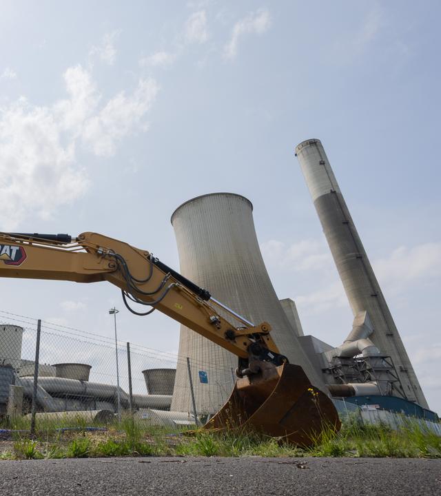 Ein Bagger ist vor dem RWE Braunkohlekraftwerk Frimmersdorf mit seinen Kühltürmen zu sehen. 