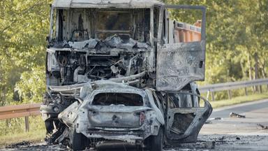 Ein ausgebrannter Lastwagen (hinten) und ein ausgebranntes Auto stehen nach einer Frontalkollision an der Unfallstelle im Kreis Erlangen-Höchstadt.