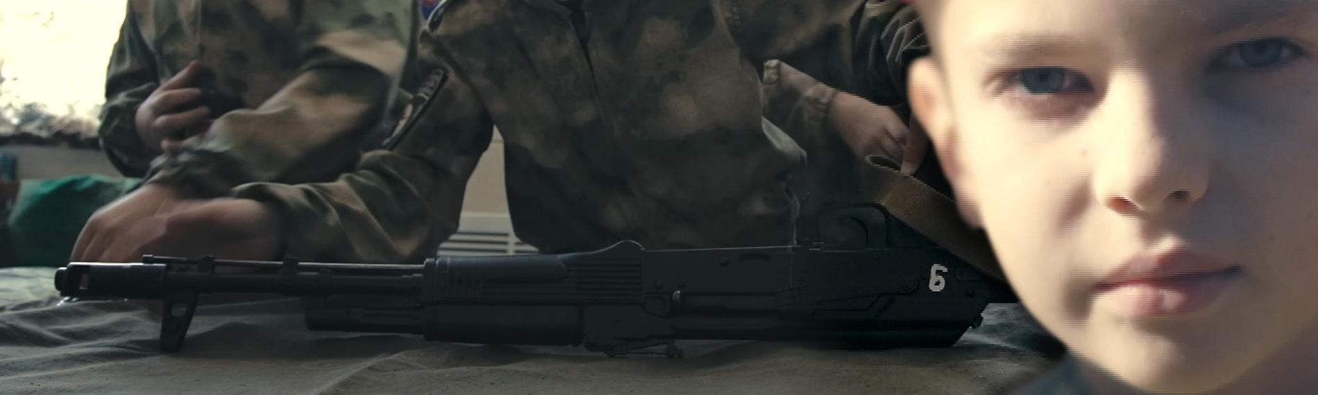 Montage: Kinder werden an Waffen ausgebildet