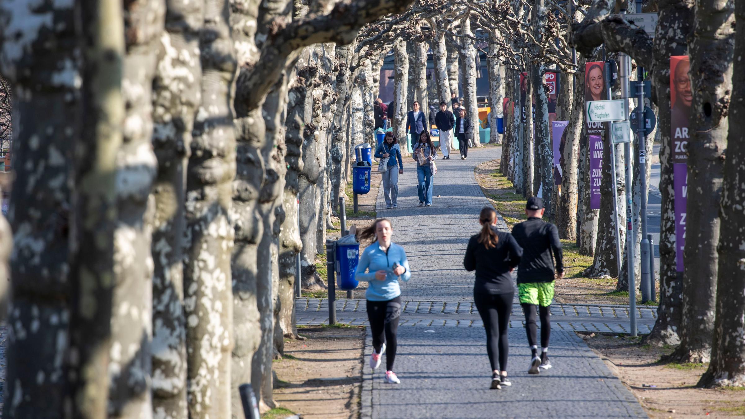 Hessen, Frakfurt: Jogger, Spaziergänger und Sonnenhungrige sind am Mainufer unterwegs.