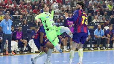 Der deutsche Handballspieler Nils Lichtlein versucht sich im Zweikampf gegen seine Kontrahenten vom FC Barcelona durchzusetzen