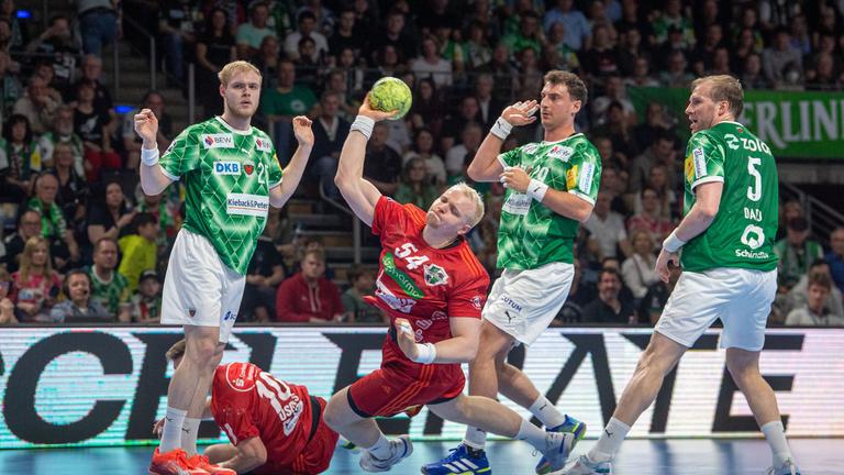 Justus Fischer (Hannover, M) wirft ein Tor gegen Matthes Langhoff (Füchse Berlin), Lukas Herburger (Füchse Berlin) und Max Darj (Füchse Berlin).