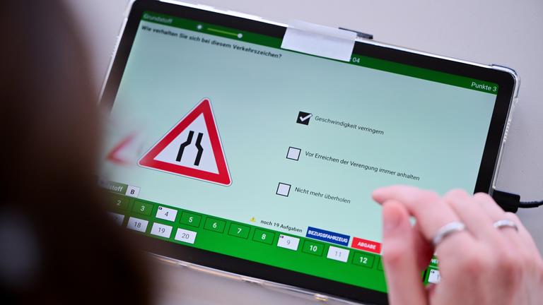 Eine Frau beantwortet im Dekra Standort Berlin-Hohenschönhausen eine Frage der theoretischen Prüfung des Führerscheins.