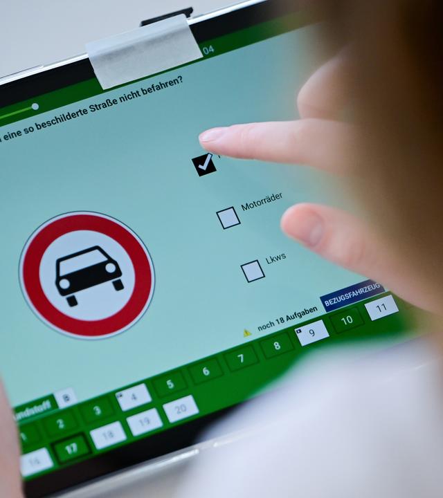 Eine Frau beantwortet eine Frage der theoretischen Prüfung des Führerscheins (Illustration)