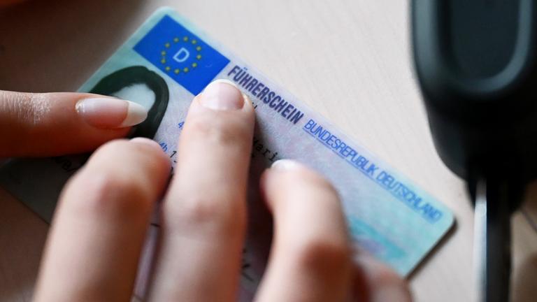 Ein Führerschein und ein Autoschlüssel liegt auf dem Tisch.