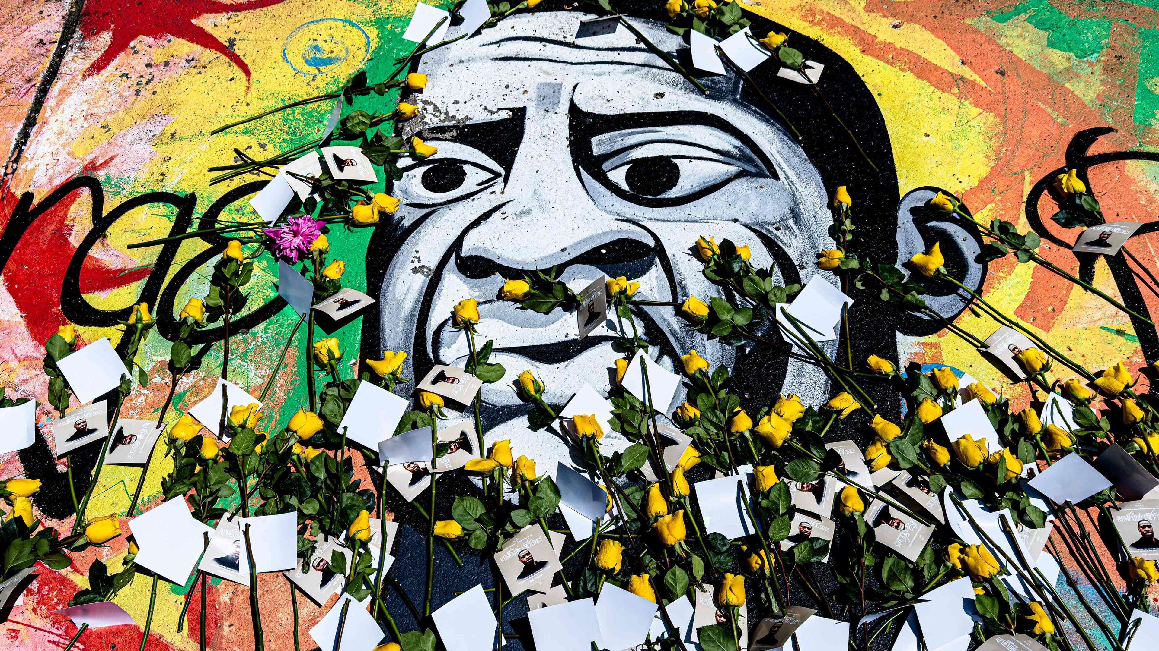 Ein Gemälde von George Floyd, auf dem Blumen und Botschaften abgelegt wurden
