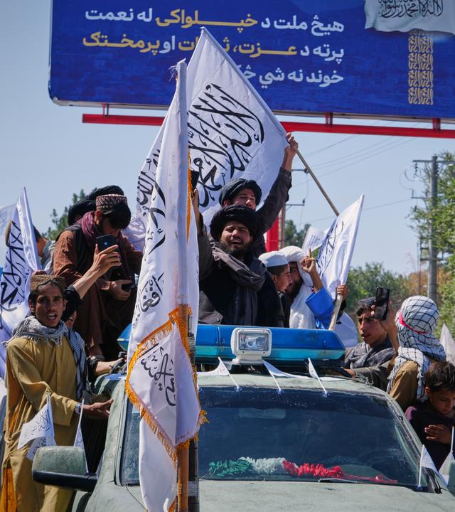 Anhänger der Taliban-Regierung fahren auf einem Fahrzeug in Kabul.