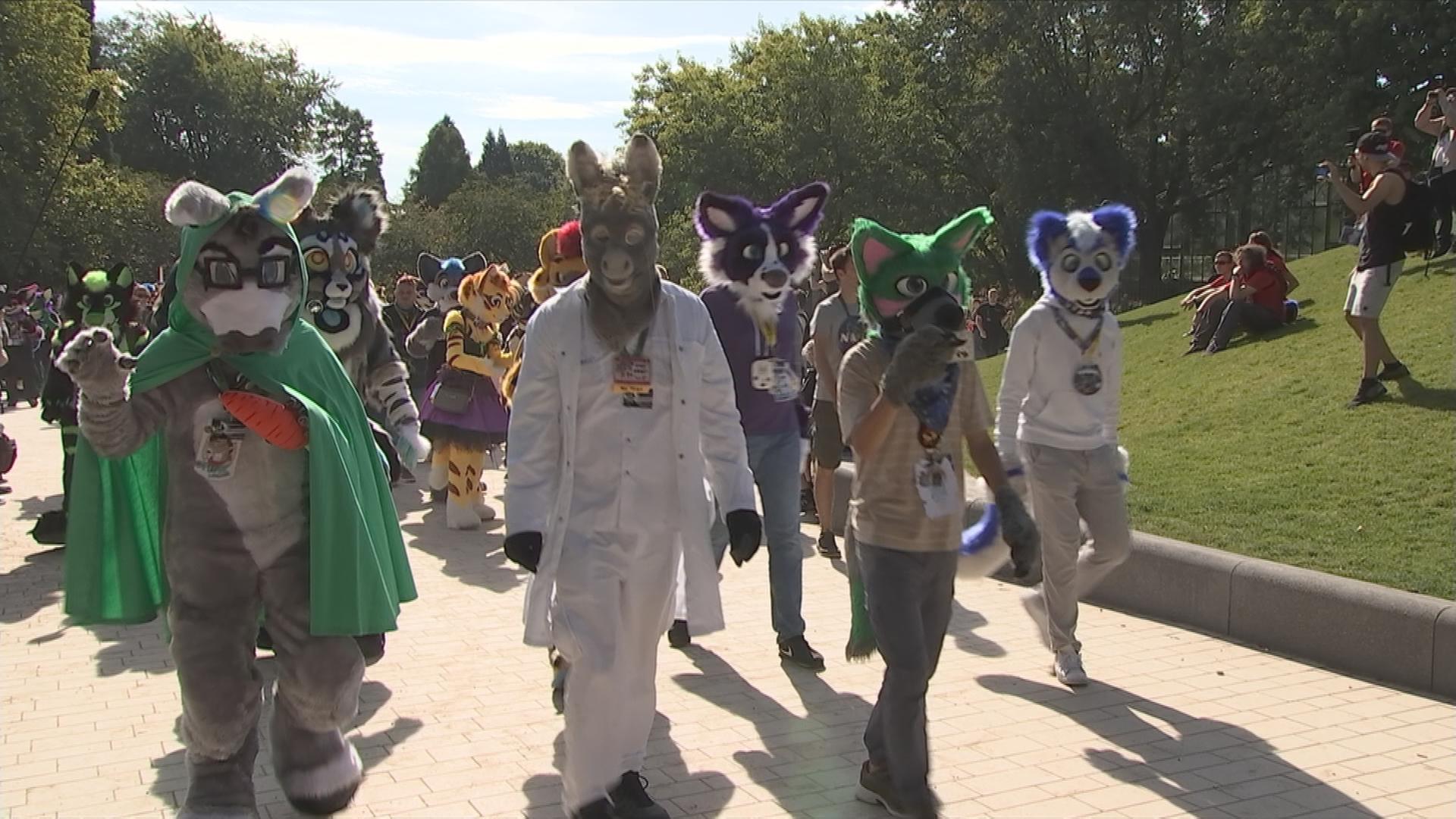 Menschen in Tierkostümen laufen durch einen Park bei Furry-Convention in Hamburg