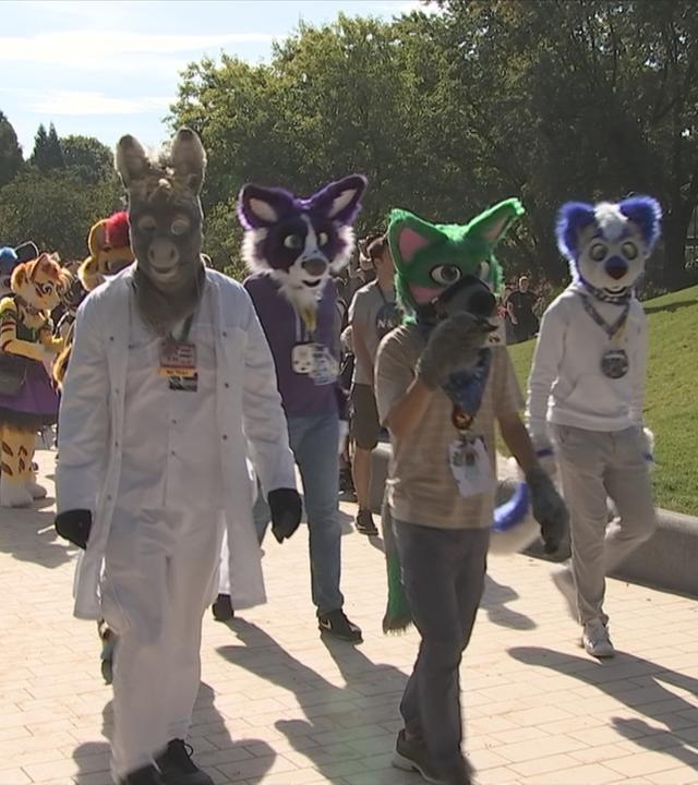 Menschen in Tierkostümen laufen durch einen Park bei Furry-Convention in Hamburg