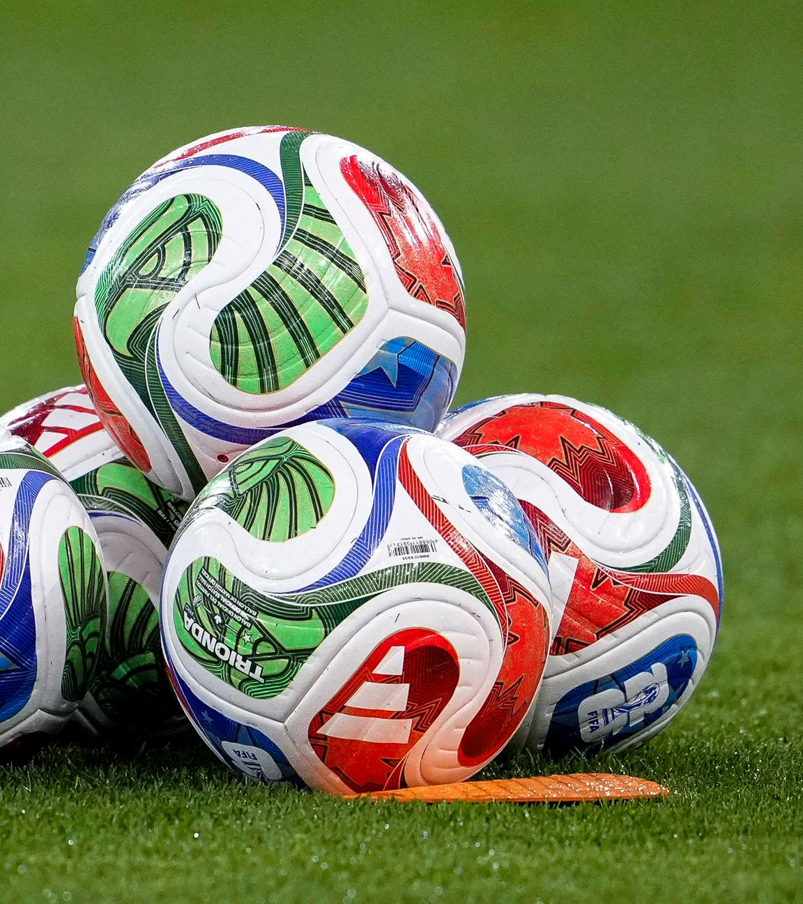 Fußbälle der Marke adidas liegen auf einem Fußballrasen am 10.10.2025.