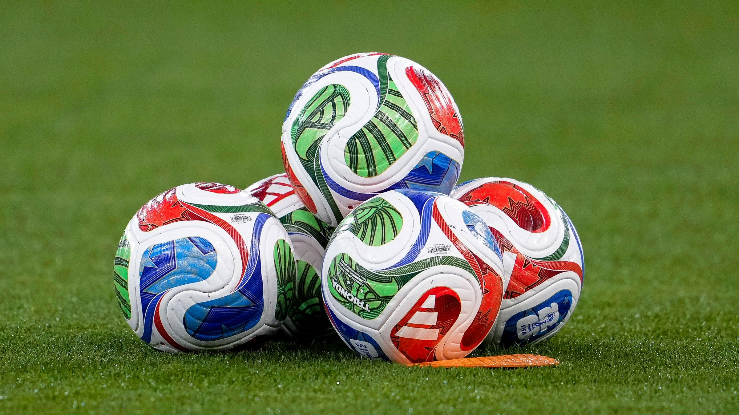 Fußbälle der Marke adidas liegen auf einem Fußballrasen am 10.10.2025.