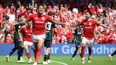 Brandenburg, Cottbus: Fußball, Männer: 2. Bundesliga, FC Energie Cottbus - Hannover 96, 1. Spieltag, LEAG Energie Stadion, Justin Butler (FC Energie Cottbus, l) jubelt nach seinem Tor zum 3:1 mit Leonardo Bittencourt (FC Energie Cottbus).