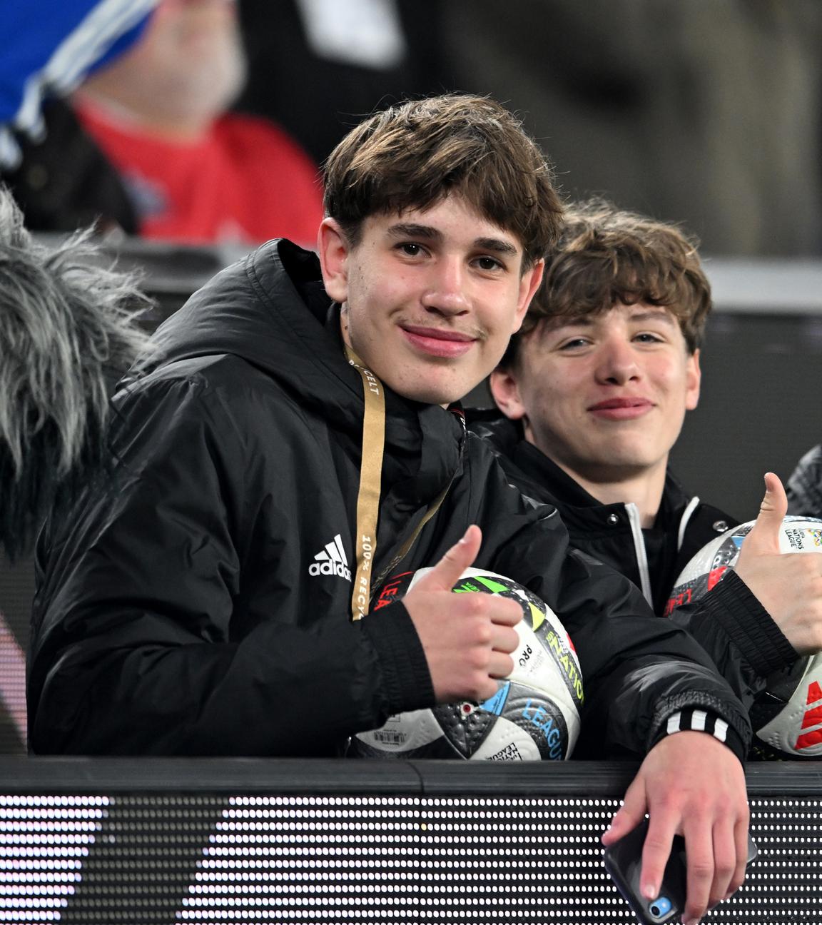 Balljunge Noel Urbaniack (l) und weitere Balljungen sitzen hinter der Bande.