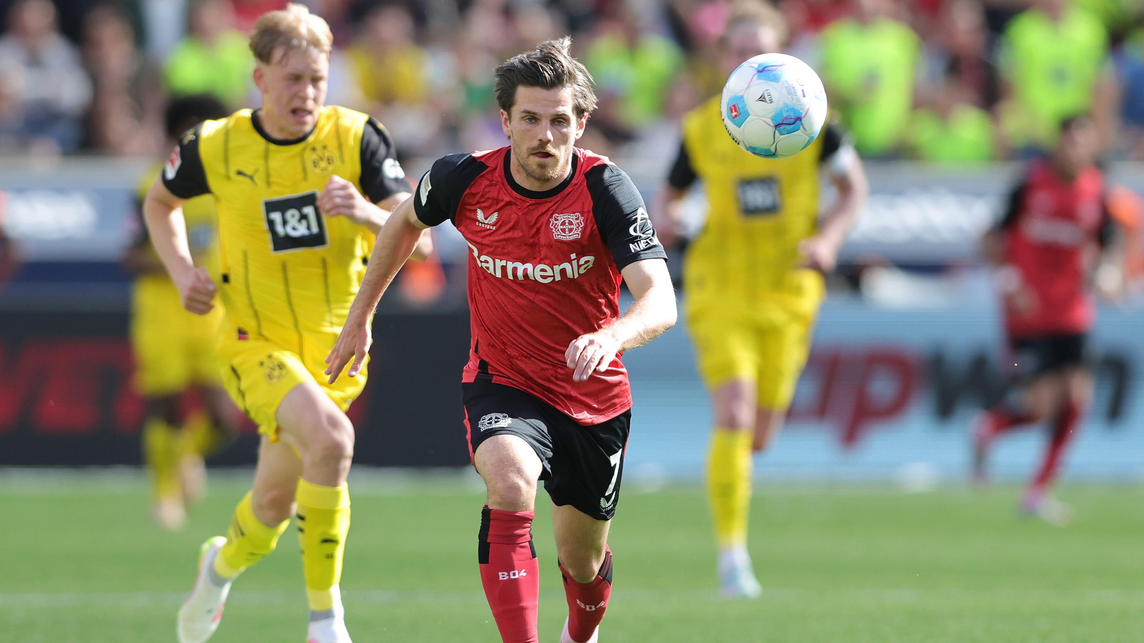 Jonas Hofmann von Bayer Leverkusen und der Dortmunder Daniel Svensson im Laufduell (Archivfoto vom 11. Mai 2025).