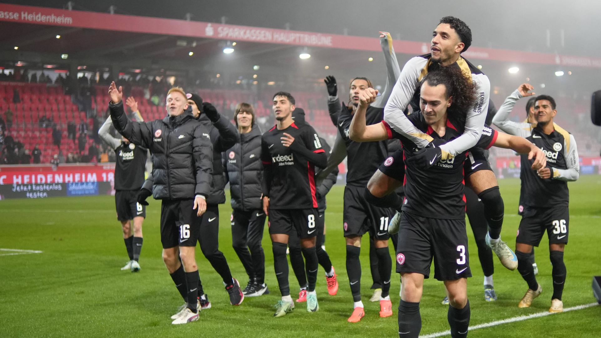 Fußball, Bundesliga, 1. FC Heidenheim - Eintracht Frankfurt: Willian Pacho (3 Eintracht Frankfurt) und Omar Marmoush (7 Eintracht Frankfurt) feiern nach dem Sieg mit den Fans beim Bundesligaspiel 1. FC Heidenheim - Eintracht Frankfurt