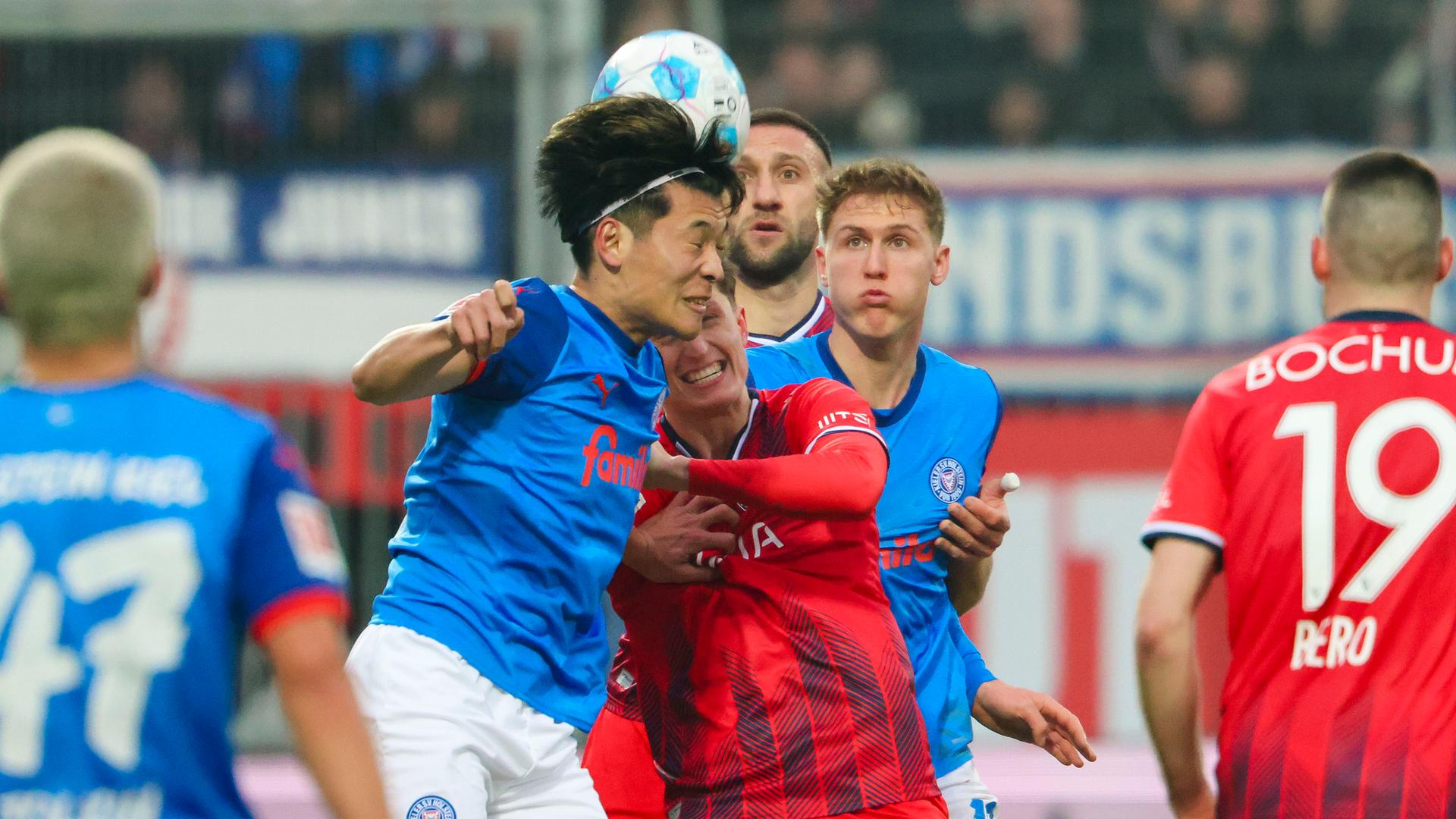 Fußball: Bundesliga, Holstein Kiel - VfL Bochum, 21. Spieltag, Holstein-Stadion. Kiels Shuto Machino (l) und Bochums Tim Oermann kämpfen um den Ball.