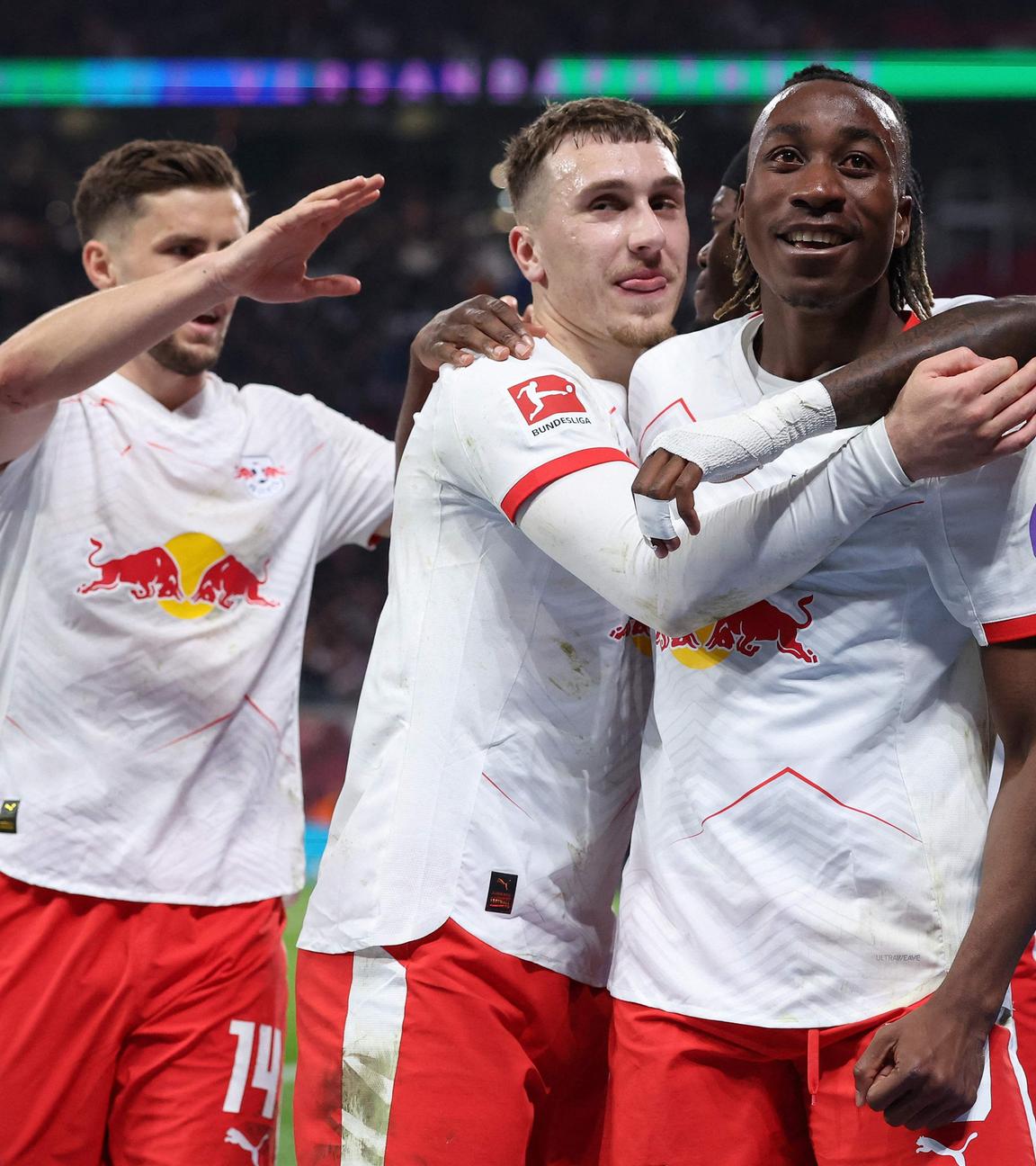 Brajan Gruda (Mitte) von RB Leipzig feiert mit seinen Teamkollegen Yan Diomande (rechts) und Christoph Baumgartner das Tor zum 4:0 gegen 1899 Hoffenheim.