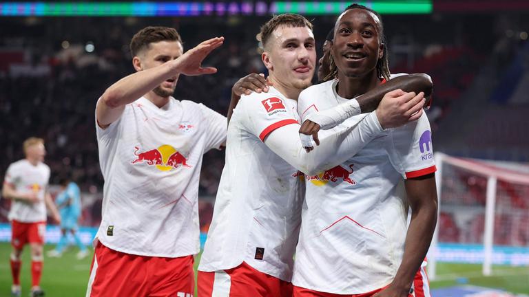 Brajan Gruda (Mitte) von RB Leipzig feiert mit seinen Teamkollegen Yan Diomande (rechts) und Christoph Baumgartner das Tor zum 4:0 gegen 1899 Hoffenheim.