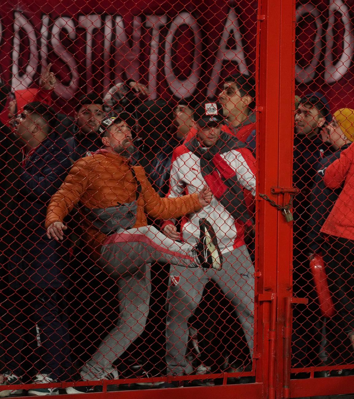 Fans der argentinischen Mannschaft Independiente schlagen während des Achtelfinal-Rückspiels der Copa Sudamericana gegen Universidad de Chile im Stadion Libertadores de America gegen eine Absperrung.