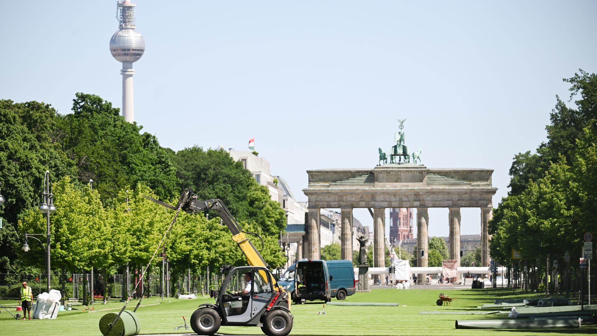 Rollrasen wird auf der Straße des 17. Juni vor dem Brandenburger Tor verlegt. Hier entsteht die Fanzone mit Public Viewing für die Fußball-Europameisterschaft vom 14. Juni bis zum 14. Juli.