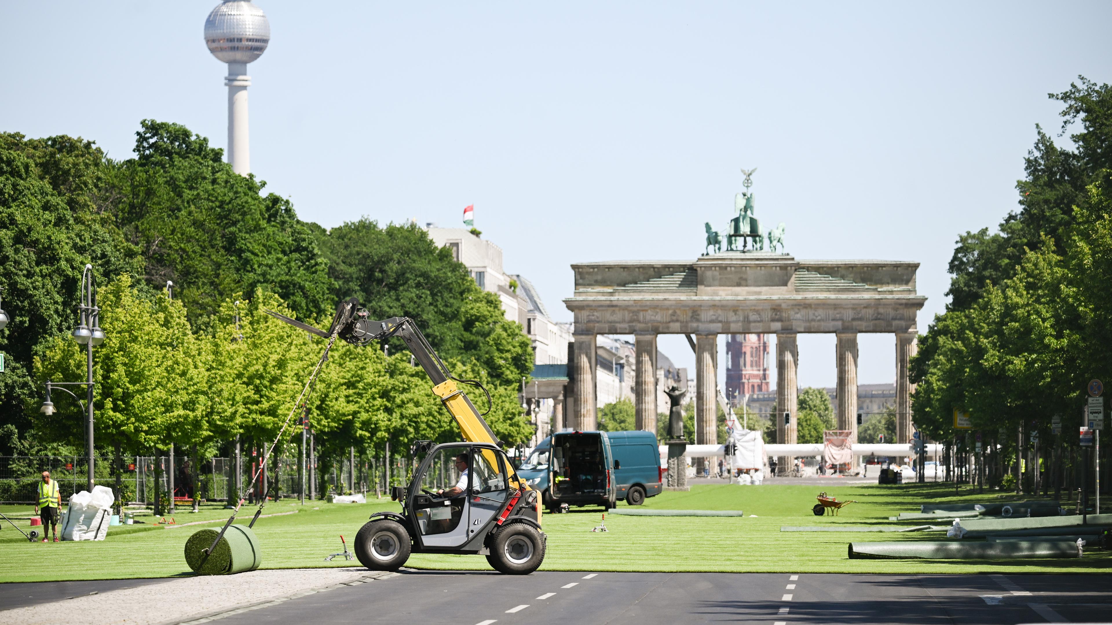 Rollrasen wird auf der Straße des 17. Juni vor dem Brandenburger Tor verlegt. Hier entsteht die Fanzone mit Public Viewing für die Fußball-Europameisterschaft vom 14. Juni bis zum 14. Juli.