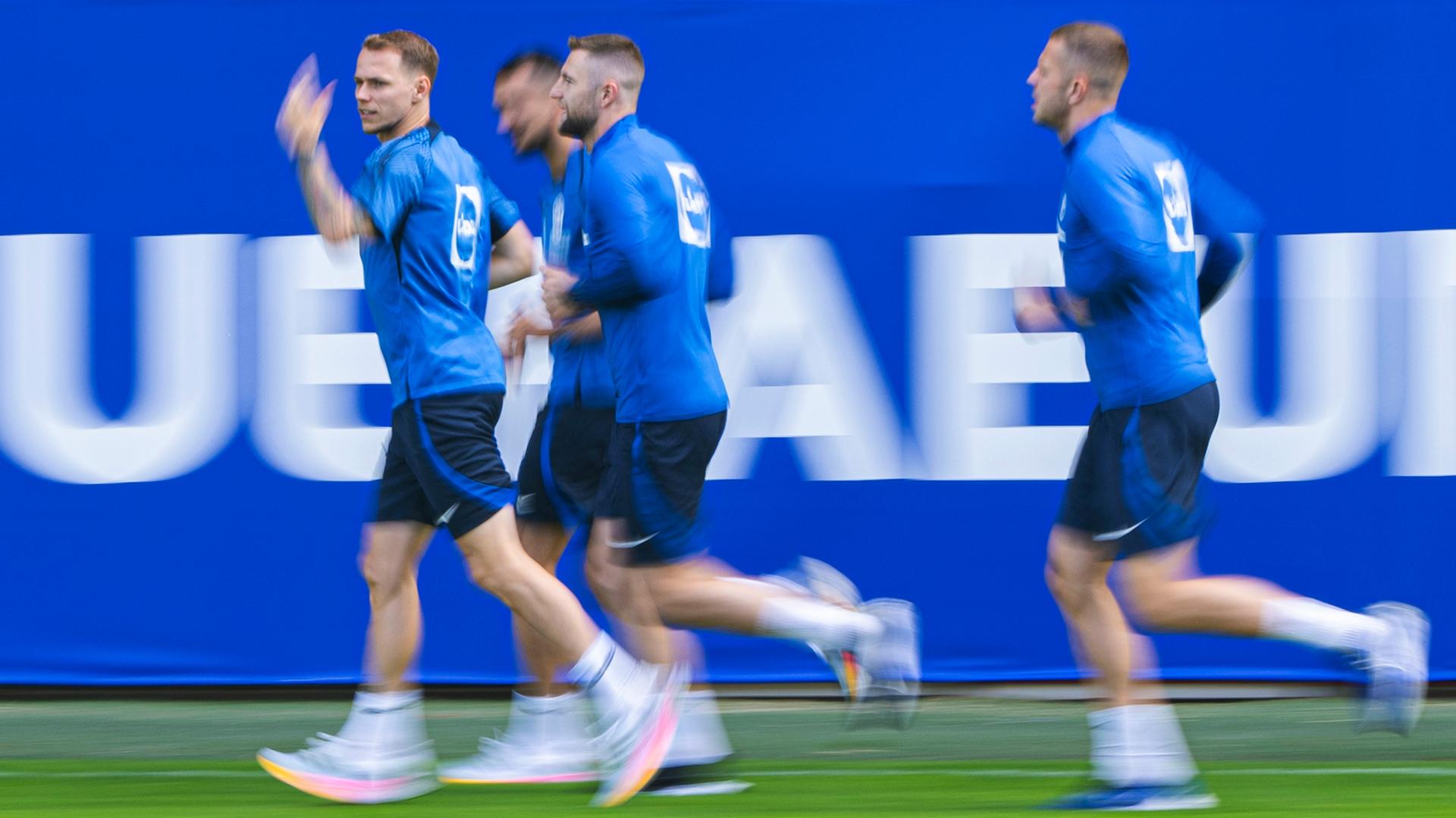 Der slowakische Fußballnationalspieler Ondrej Duda (l) winkt neben seinen Teamgefährten während des Trainings am 23.06.2024