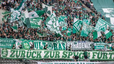 Es sind Fans mit Schals des SpVgg Greuther Fürth zu sehen