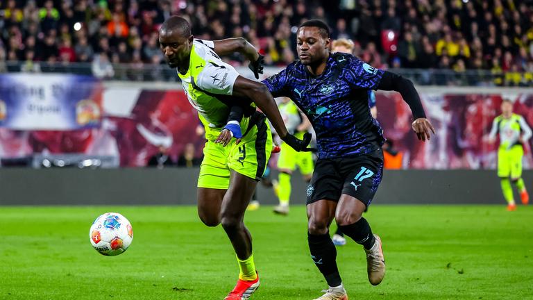 Serhou Guirassy (Borussia Dortmund) und Ridle Baku (RB Leipzig) kämpfen. 