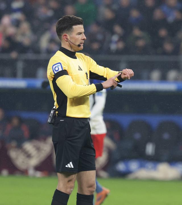 Schiedsrichter Harm Osmers zeigt beim Bundesliga-Spiel zwischen dem HSV und Bayern München auf die Uhr wegen Zeitspiel (31.01.2026).