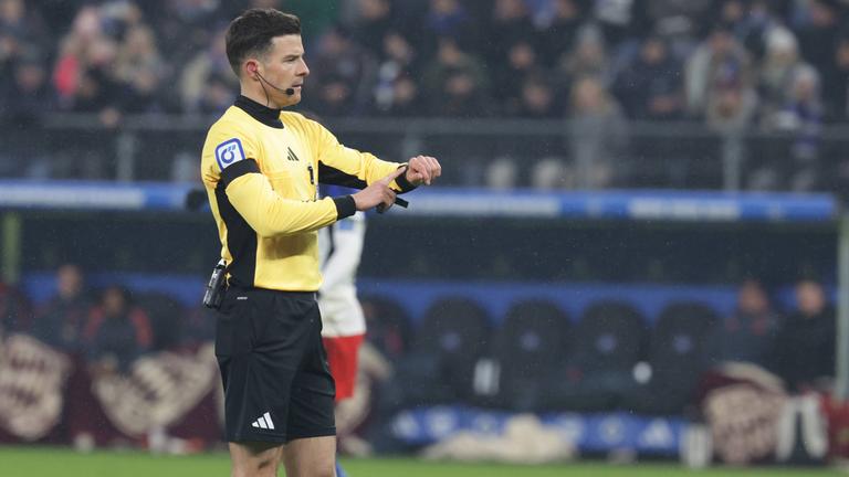 Schiedsrichter Harm Osmers zeigt beim Bundesliga-Spiel zwischen dem HSV und Bayern München auf die Uhr wegen Zeitspiel (31.01.2026).