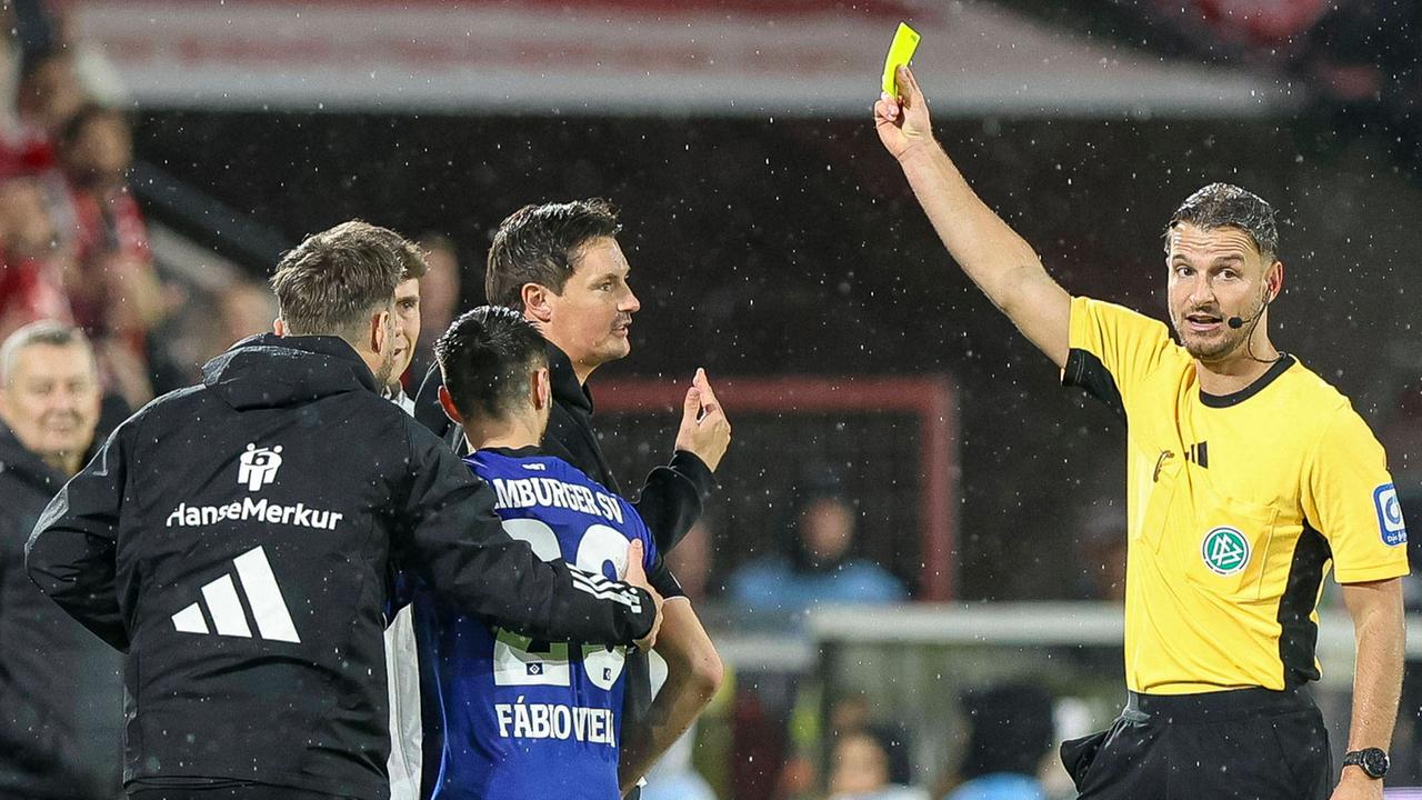 Trainer Merlin Polzin (Hamburger SV) erhält die gelbe Karte von Schiedsrichter Daniel Schlager während des Spiels der Bundesliga zwischen 1. FC Köln vs Hamburger SV am 02.11.25 im Rhein-Energie-Stadion in Köln. 