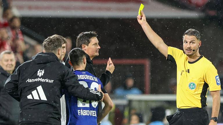 Trainer Merlin Polzin (Hamburger SV) erhält die gelbe Karte von Schiedsrichter Daniel Schlager während des Spiels der Bundesliga zwischen 1. FC Köln vs Hamburger SV am 02.11.25 im Rhein-Energie-Stadion in Köln. 
